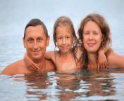 glückliche familie mit kleinem mädchen baden im meer 11808980.jpg from fkk jpg