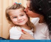 young mother kissing her small daughter cute having fun home family portrait 38998099.jpg from funny cute mom kiss