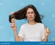 middle aged brunette woman combing her long beautiful hair wooden comb screaming loudly pain standing blue 260658001.jpg from beautiful loudly pai