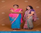 studio shot two mature indian women wearing sari traditional clothes together against brown background 129604371.jpg from mature tamil wife wearing saree