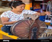 older burmese female weaver uses a spinning wheel to create thread for weaving traditional fabrics of the bagan pagan region of myanmar burma 2aa88wx.jpg from myanmar phongyi