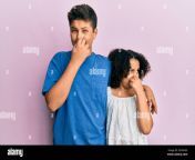 young hispanic family of brother and sister wearing casual clothes together smelling something stinky and disgusting intolerable smell holding breat 2ehxh55.jpg from sister smell