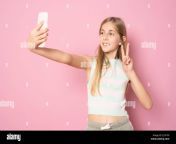 excited little blonde kid girl 11 12 years old in summer clothing doing selfie isolated on pink background childhood lifestyle concept 2j1x1px.jpg from 12 sal ki ladki sel