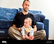 funny baby sitting on his fathers legs resting relaxed rtd3k7.jpg from sit on his leg