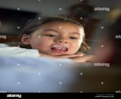 cute little asian girl looking in the mirror showing of the gap between her milk teeth as she is changing teeth tx6gnm.jpg from a cute changing and showing