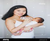 portrait of young chinese asian mother feeding newborn baby son daughter with milk formula from bottle authentic lifestyle candid real moment real m wat7gg.jpg from mom china milk big 3gphi dabi xxx naked photos
