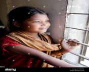 young bangladeshi girl looks out of barred window bjn09j.jpg from bangla small gal