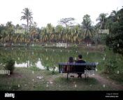 a couple sitting on a park bench overlooking a lake in dhaka bangladesh b0xhgx.jpg from outdoor bangla park