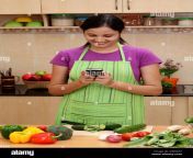 smiling young woman in kitchen doing texting dw6667.jpg from indian young house wife and hosband sex videos