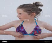 young caucasian girl wearing a bikini looking to her right adjusting e6jgrd.jpg from young in bikinis