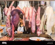 local woman stallholder behind meat displayed at a butchers market e94bcp.jpg from woman meat
