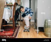 mixed race boy riding skateboard in kitchen e8tcjb.jpg from riding in kitchen
