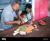smiling man looking at boy cutting onion with father in kitchen at jgf271.jpg from dad son onion
