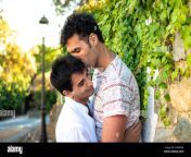 un nino besando a su novio joven pareja gay enamorada dos jovenes gays al aire libre en verano en una calle suburbana orgullosa pareja de un chico caucasico marron 2gf8xn0.jpg from video dos gay